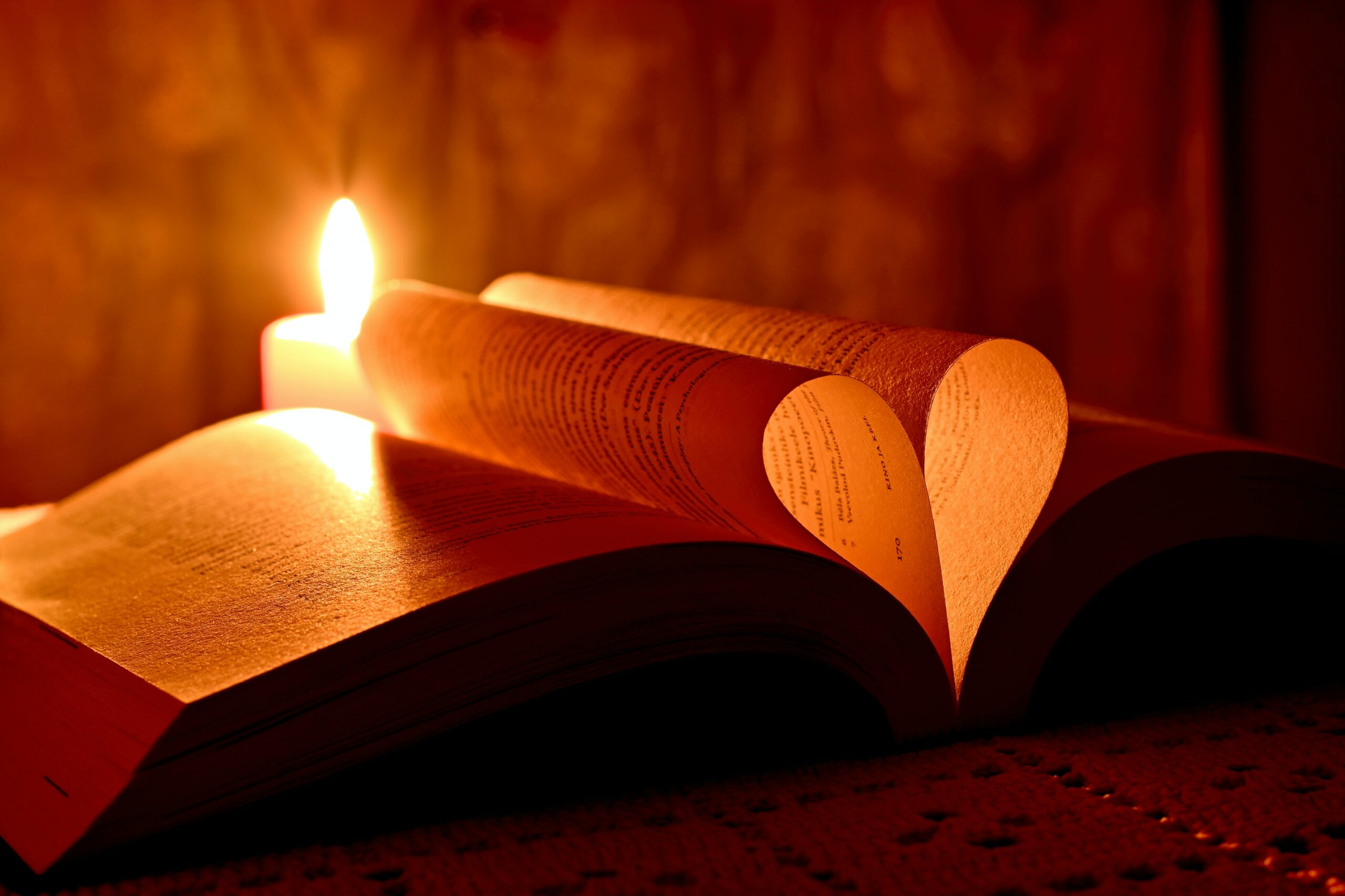 Candle behind bible and heart