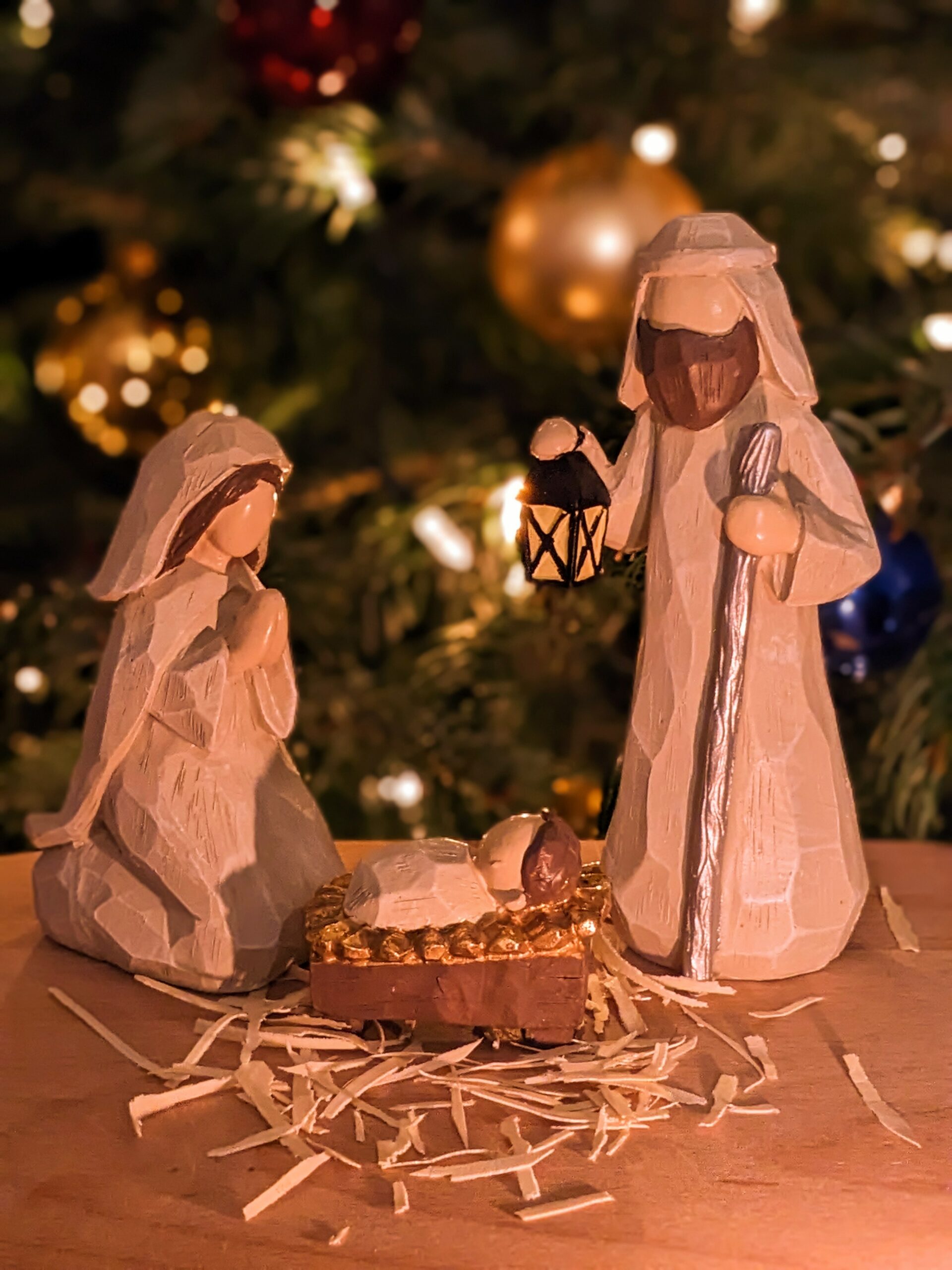 Nativity figures in front of Christmas tree