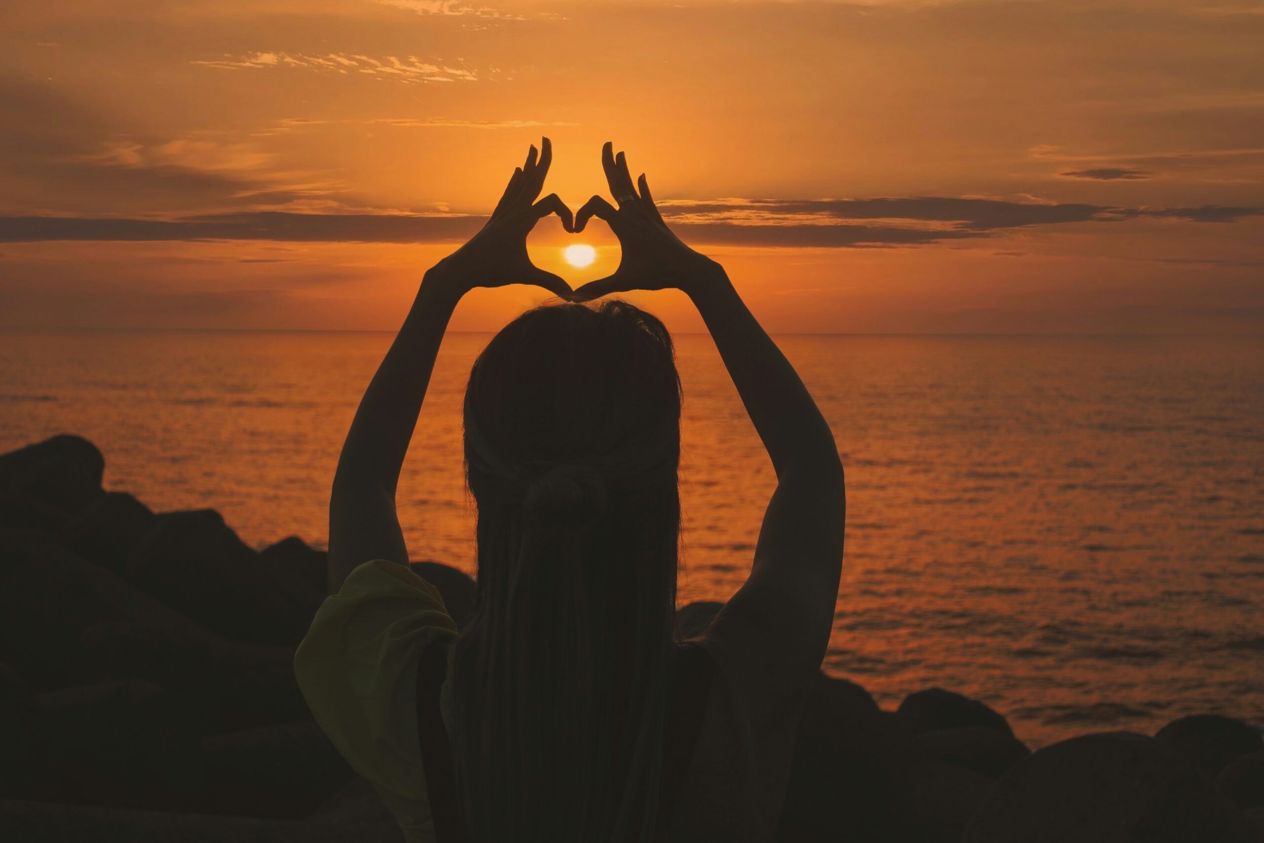aziz acharki heart made of hands against sunset