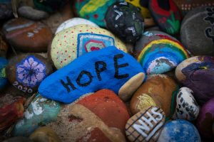 Painted pebbles with rainbows and the word HOPE